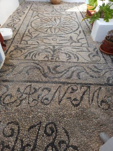 un sol en mosaïque avec inscription sur un trottoir dans l'établissement Angelica, à Frý
