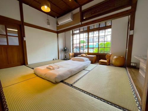 a bedroom with a large bed in a room with windows at 勝利文旅日式民宿 in Pingtung City