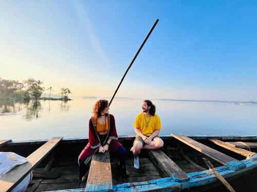 two women sitting on a boat on the water at Riverrootsstays in Munroe Island