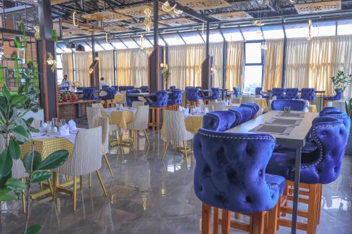 a restaurant with blue chairs and tables in a room at South Gate Hotel Apartment in Addis Ababa