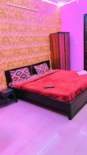 a large bed in a room with a red bedvisor at Hotel shayam in New Delhi
