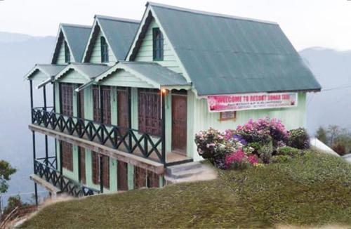 a house on top of a hill with flowers at Resort Sonar Tari in Kalimpong