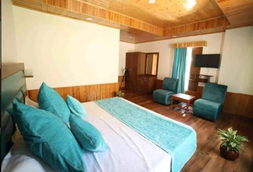 a bedroom with a large bed with blue pillows at The king hill resort in Goa