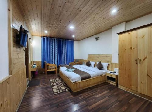 The king hill resort في Goa: غرفة نوم بسرير وتلفزيون في غرفة