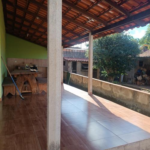 a porch with a wooden table and a wooden floor at Condomínio vale Araçás in Mateus Leme