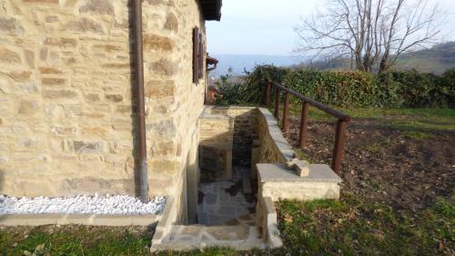 ein Steingebäude mit einer Treppe neben einem Haus in der Unterkunft Gnazzano Home 2 in Loiano