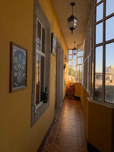 un pasillo con paredes y ventanas amarillas en un edificio en Casa de los Abuelos Hotel, en Tecpán Guatemala