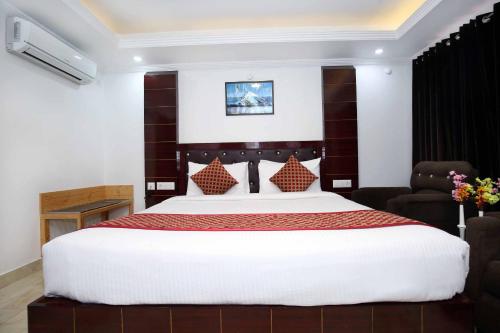 a bedroom with a large bed and a chair at Hotel White Grand Shimla - IN CITY CENTRE - A Centrally AC Hotel in Shimla