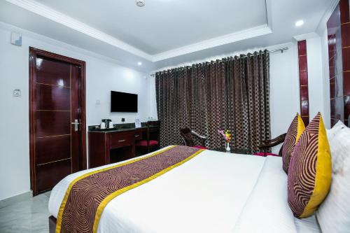 a bedroom with a bed and a desk and a television at Hotel White Grand Shimla - IN CITY CENTRE - A Centrally AC Hotel in Shimla