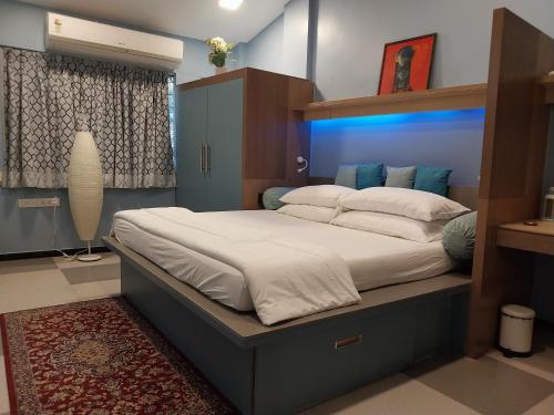 a bedroom with a large bed with a blue headboard at NeXstage Terraces, The Blue Lagoon Suite, Carter Road, Bandra West in Mumbai