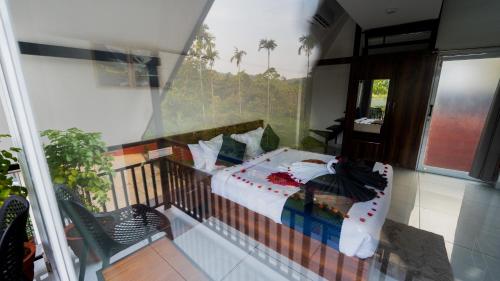 Schlafzimmer mit einem Bett auf einem Balkon in der Unterkunft Silent Planet Resort in Koroth