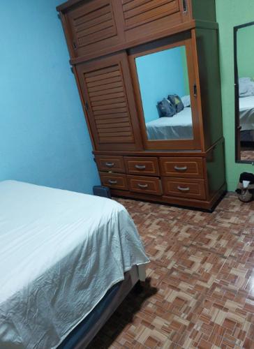 a bedroom with a bed and a dresser with a mirror at Pequeña habitacion Amatitlan in Amatitlán