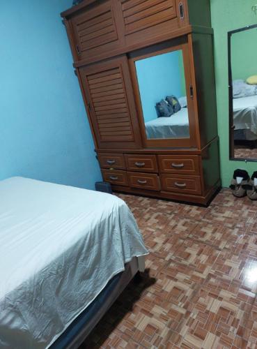 1 dormitorio con tocador, cama y espejo en Pequeña habitacion Amatitlan, en Amatitlán