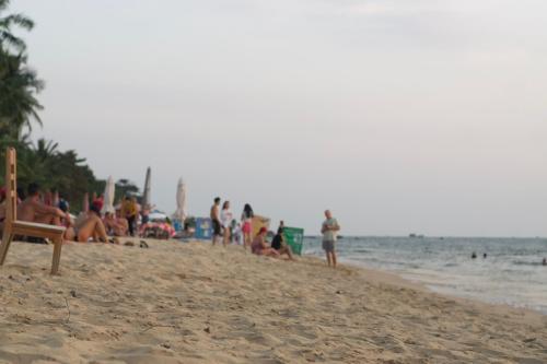 a group of people sitting on the beach at Duong Hieu Guesthouse in Phu Quoc