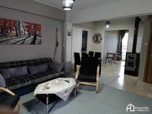 un soggiorno con divano e tavolo di Άνετο και ήσυχο διαμέρισμα με θέα a Calcide