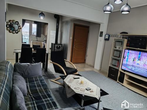 ein Wohnzimmer mit einem Sofa und einem TV in der Unterkunft Άνετο και ήσυχο διαμέρισμα με θέα in Chalkida