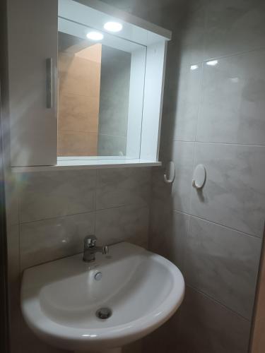 La salle de bains est pourvue d'un lavabo blanc et d'un miroir. dans l'établissement Kipseli 1, à Kozani