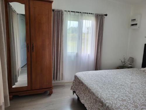 um quarto com uma cómoda, uma cama e uma janela em Case Créole Soalaze em Salazie