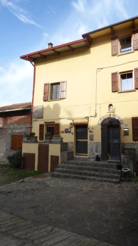 un gran edificio amarillo con escaleras delante en Gnazzano Home 1, en Loiano