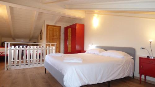 a bedroom with a white bed and a crib at Gnazzano Home 1 in Loiano