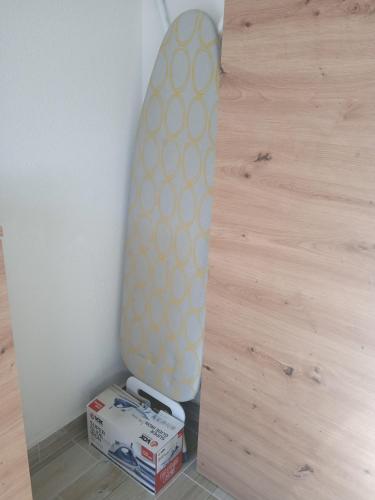 a surfboard leaning against a wall next to boxes at MAL Apartman in Soko Banja