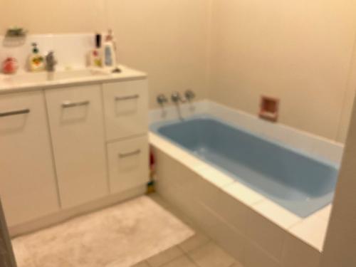 uma casa de banho com uma banheira azul e um lavatório. em Do Drop Inn 188 Clarke St east, CAREY PARK W A em Carey Park