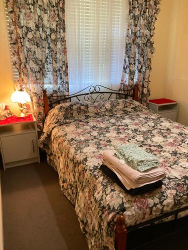 um quarto com uma cama e uma janela com cortinas em Do Drop Inn 188 Clarke St east, CAREY PARK W A em Carey Park