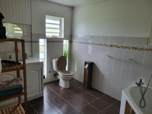 uma casa de banho com um WC e uma janela em Case Créole Soalaze em Salazie