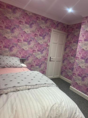 a bedroom with a bed and a pink wall at Prime Alexandra Place in Chatham