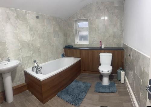 a bathroom with a tub and a toilet and a sink at Prime Alexandra Place in Chatham