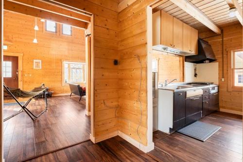 a kitchen in a log cabin with a stove at 森の中の大型ログハウス最大16名可ペット同伴OkコテージLog in Nasu