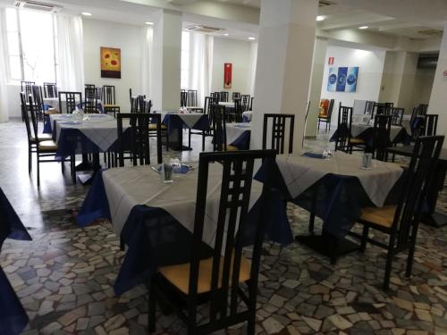 una sala da pranzo con tavoli e sedie con tovaglie blu di Sacro Cuore Hotel a Massa