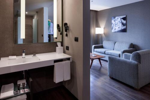 uma casa de banho com um lavatório e um sofá num quarto em AC Hotel by Marriott Santa Fe em Cidade do México