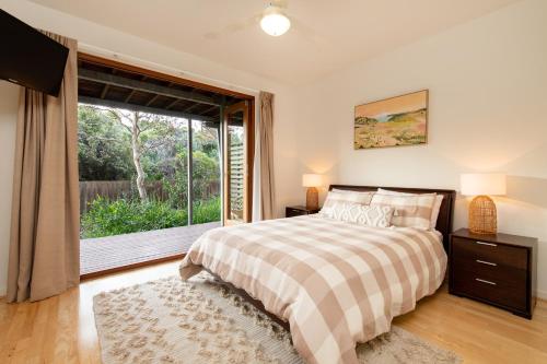 een slaapkamer met een bed en een groot raam bij Dunes Villa South Shores Normanville walk to beach in Normanville