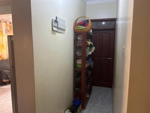 a closet with a shelf and a basket on the wall at Boys Guest house in Wakiso