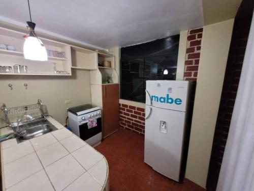 een kleine keuken met een witte koelkast en een wastafel bij Departamento a 2 cuadras de plaza in Ayacucho