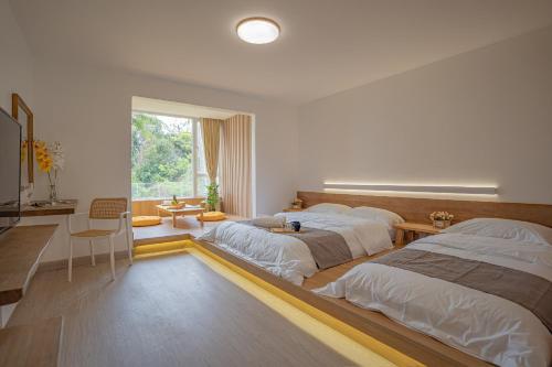 a bedroom with two beds and a desk at BIDONG VIEW RESORT in Kuala Terengganu