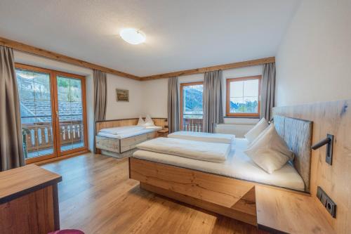 a bedroom with two beds in a room with windows at Karlingerhof in Achenkirch