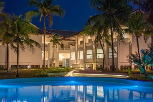 瓜拉丁加奴的住宿－BIDONG VIEW RESORT，一座棕榈树环绕的建筑,位于游泳池前