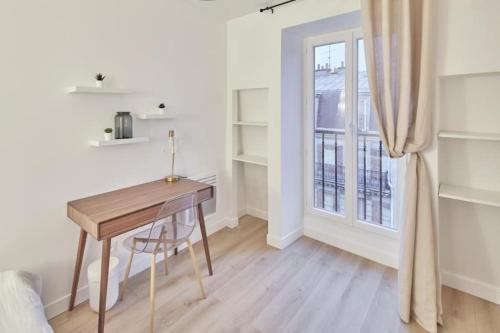 Cette chambre dispose d'un bureau en bois et d'une fenêtre. dans l'établissement Calm & Cosy flat in Levallois, à Levallois-Perret
