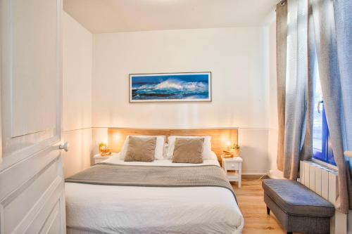 a bedroom with a large bed and a window at La Maison de Pêcheur de Ginette in Cabourg