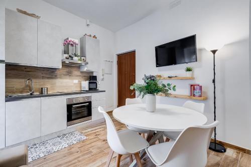 uma cozinha branca com uma mesa e cadeiras brancas em Casa Vacanze Ciampino airport and train station em Ciampino