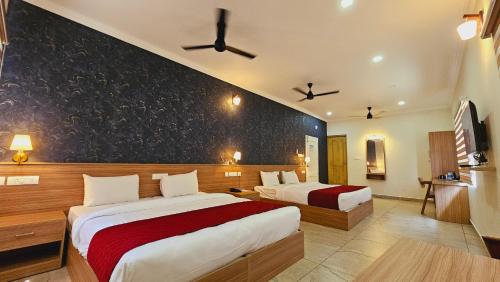 a hotel room with two beds and a black wall at ESAA Airport Hotel in Cochin