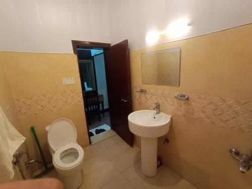 a bathroom with a toilet and a sink at Arena Lodge Guesthouse in Islamabad