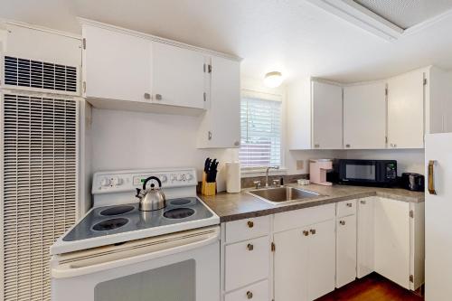 a kitchen with white cabinets and a stove top oven at Klamath Comfort in Klamath Falls