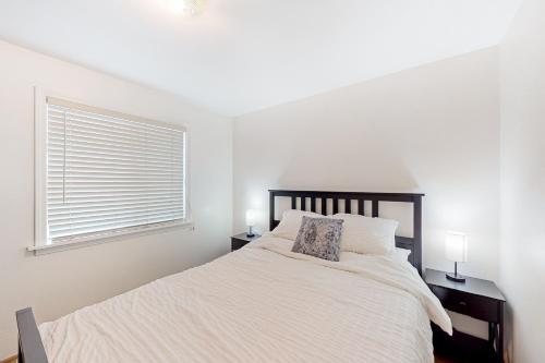 a white bedroom with a bed and a window at Klamath Comfort in Klamath Falls