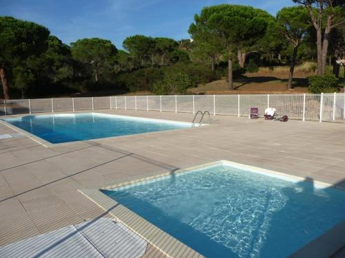 une grande piscine dans une cour avec une clôture dans l'établissement Villa domaine de la Pinède Golfe Saint Tropez, à La Garonnette-Plage