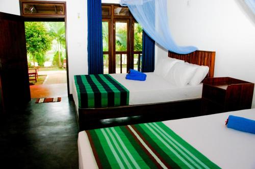 a bedroom with two beds and a window at Pride Rock Villa in Sigiriya