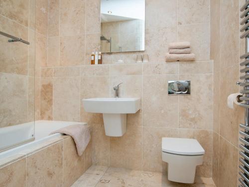 a bathroom with a sink and a toilet and a bath tub at Royal Crescent Apartment in Bath