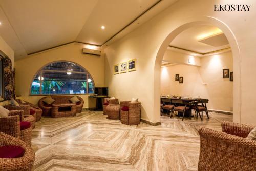 a lobby with a table and chairs and a dining room at EKOSTAY - Polaris Villa in Majorda